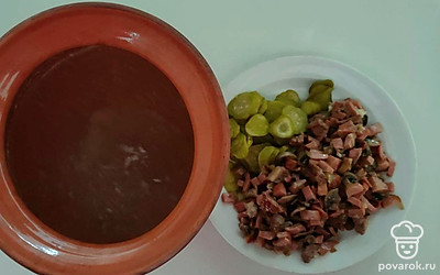 Нарежьте огурец кружочками. Бульон перелейте в горшочек, положите в него обжаренные ингредиенты и огурцы.