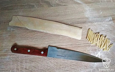 Готовое тесто разделите на 3 части, каждую тонко раскатайте, сверните рулетом и тонко нарежьте острым ножом, взрыхлите лапшу руками, посыпьте мукой и оставьте подсыхать на 20 минут.