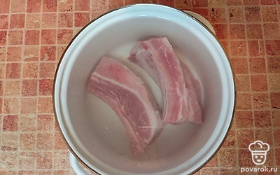 Когда ребрышками начнут кипеть, слейте первый бульон, залейте их чистой водой и поставьте снова на огонь. Доведите до кипения, убавьте огонь и варите 40 минут.