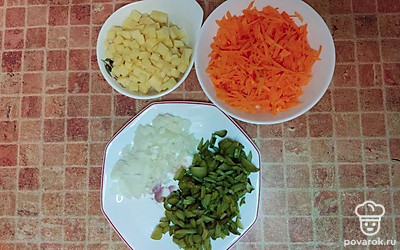 Нарежьте картофель, лук и маринованные огурцы. Морковь натрите на крупной терке.