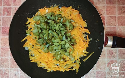 Обжарьте на растительном масле лук и морковь, добавьте огурцы, закройте крышку и тушите 10 минут.