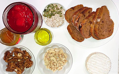 Орехи и фундук насыпьте в глубокие тарелочки, затем абрикосы поместите на стол. Хлеб порежьте на кусочки. Сыр поместите на стол.