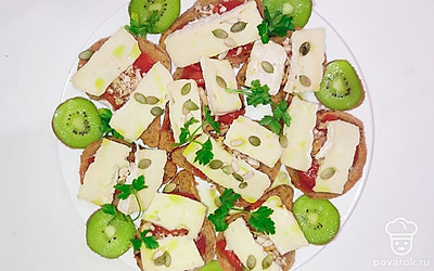 Сыр порежьте на тоненькие слайсы и уложите сверху орехов. Посыпьте подсолнечными и тыквенными семечками.