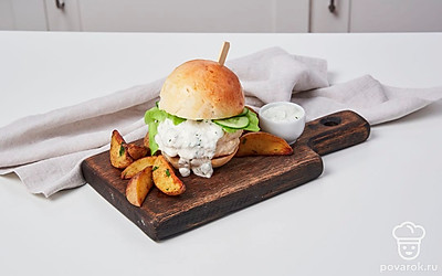 На половину каждой булочки выложите по котлете, смажьте соусом. Разложите ломтики огурца и листья салата. Прикройте второй половиной булочки и подавайте.