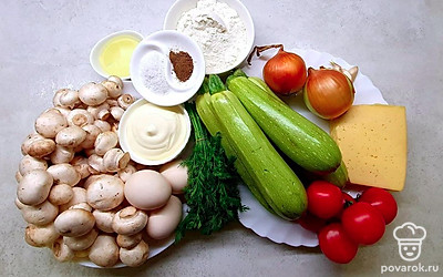 Кабачки промойте, обсушите бумажным полотенцем и натрите на крупной терке. Затем хорошо отожмите от сока. Очистите и измельчите чеснок. Очистите и нарежьте лук. Промойте и нарежьте грибы. Натрите сыр на крупной терке.