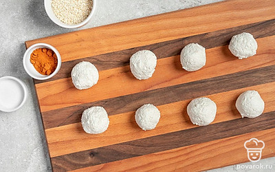 Сформируйте творожные шарики. Творог соедините с майонезом, перцем чили, солью и чесноком, активно перемешайте. Из полученной массы слепите шарики небольшого размера, выложите их на деревянную доску на расстоянии друг от друга.