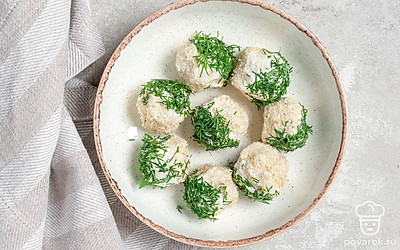 Охлажденные творожные шарики с чесноком, зеленью и кунжутом уложите на сервировочную тарелку и подайте к столу.