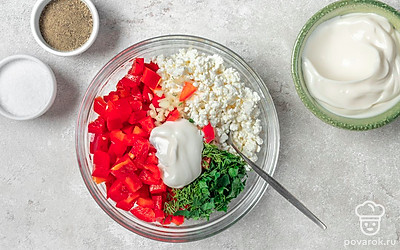 Приготовьте намазку. Соедините творог с указанным в рецепте количеством сметаны, всыпьте измельченные овощи и зелень, приправьте солью и черным молотым перцем. Активно перемешайте до однородного распределения продуктов.