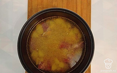 В чашу к овощам добавьте нарезанное кусочками мясо и прожарьте 8 минут. Мясо необходимо прижарить со всех сторон. Затем выложите перловую крупу, порезанные огурцы и картофель. Посолите, поперчите и влейте горячую воду. Закройте крышку, выберите режим «суп».