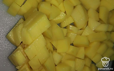 Почистите картошку и нарежьте квадратиками.