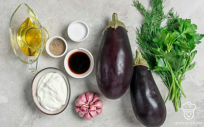 Овощи и зелень вымойте, обсушите. Баклажаны почистите, нарежьте кубиками среднего размера. Зелень измельчите. Зубчики чеснока очистите от шелухи, пропустите через терку со средними ячейками. Подготовьте погружной блендер.