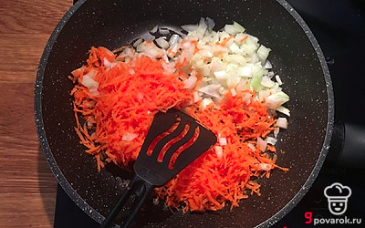 Налейте на сковороду растительное масло для жарки и разогрейте ее в течение 2 минут. Добавьте лук и морковь. 
