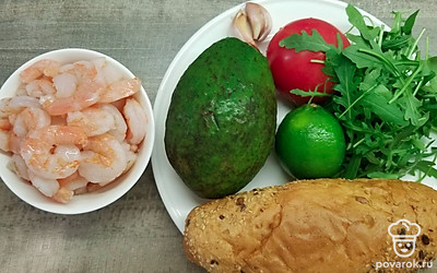 Заранее разморозьте креветки, выложите их на сито, чтобы стекла лишняя жидкость. Вымойте помидор и руколу, дайте стечь воде. Выдавите сок из лайма, очистите чеснок. Приготовьте просторную сковороду с толстым дном и антипригарным покрытием.