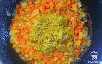 Маринованные огурцы натрите на мелкой тёрке. В сковороду добавьте измельчённый чеснок и огурцы. Протушите все овощи вместе 5 минут, иногда помешивая.