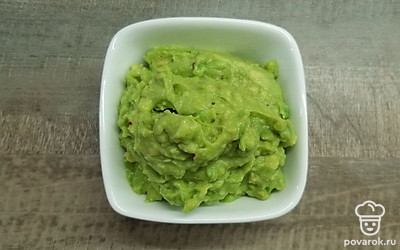 Сделайте на авокадо надрез до самой косточки по всей окружности, проверните половинки в разных направлениях и разделите их. Удалите косточку, мякоть выложите в глубокую тарелку при помощи ложки. Добавьте 1 ч.л. оливкового масла, 1 ч.л. сока лайма, соль, перец и разомните вилкой.