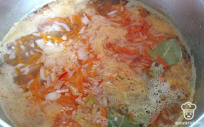 Когда вода с картофелем закипит, посолить. Добавить морковь, лук, перец, лавровый лист, рис и сливочное масло в кипящую воду.