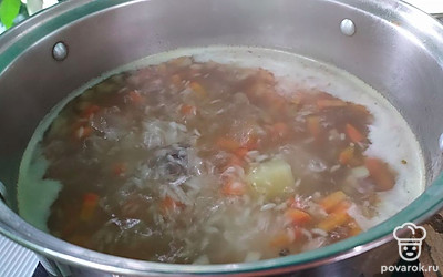 Через 5 минут всыпать рис, через 10 минут добавить обжаренные лук и морковь. Варить все вместе еще 5-7 минут.