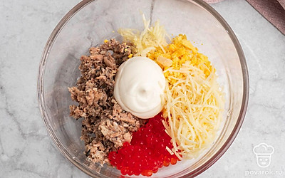 Натрите сыр на тёрке, измельчите чеснок. В глубокой удобной посуде смешайте желтки, сыр, шпроты и икру. Добавьте майонез и как следует перемешайте.