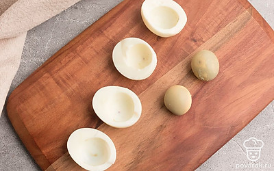 Яйца остудите и очистите. Аккуратно разрежьте пополам и удалите желток.