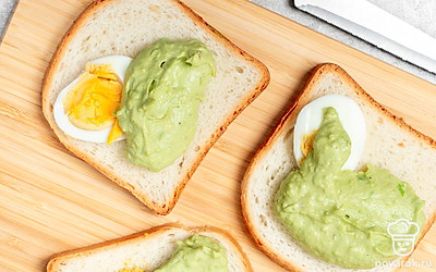 Сделайте сэндвичи. На три ломтика хлеба положите по половинке яйца. Поверх яйца выложите начинку так, чтобы она сравнялась по уровню с яйцом. Накройте пустыми хлебными ломтиками. Разрежьте на треугольники.