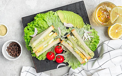 Подайте сэндвичи на листьях салата.