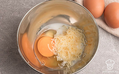 В миске соедините сыр, молоко и яйца. Перемешайте, используя вилку, так сыр распределится более равномерно.