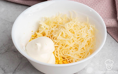 Натрите на тёрке сыр, измельчите чеснок. В удобной глубокой посуде смешайте желтки, чеснок и сыр, добавьте немного соли по вкусу. Тщательно всё перемешайте.