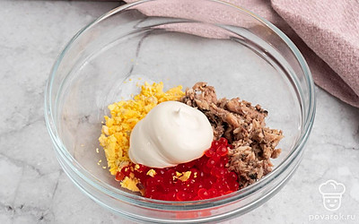 Возьмите удобную глубокую миску и положите в неё измельченные желтки, шпроты и икру, добавьте майонез. Тщательно перемешайте.