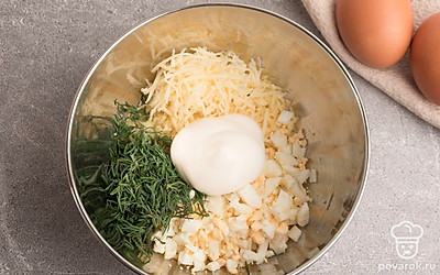 Потрите сыр. Мелко порежьте зелень и яйца. Соедините все ингредиенты в миске, добавьте майонез и все перемешайте.