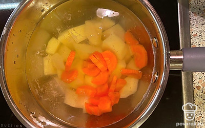 Рубленую морковь также опустите в воду и поставьте ковш на плиту. Варите 5-7 минут на слабом огне до закипания. 