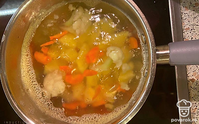 После закипания опустите в воду цветную капусту. Варите 10-12 минут на среднем огне до мягкости овощей. Не забывайте помешивать ингредиенты в ковше.