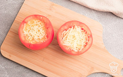 Наполните получившейся смесью помидорные чашечки. Сверху присыпьте оставшимся сыром.