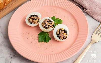 Блюдо готово! Возьмите красивую тарелку, выложите на неё фаршированные яйца и украсьте их листочками петрушки. Можно подавать к столу!