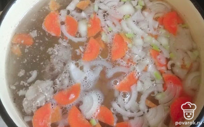 В готовый бульон с кусочками говядины добавить нарезанный лук и морковь. 