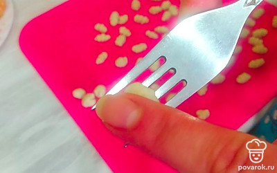 Пальцем прижать тесто и прокатывать его по вилке. 