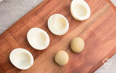 Готовые яйца остудите и очистите. Разрежьте пополам и отделите белки от желтков.