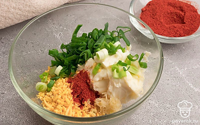 В емкости соедините лук, желток, плавленый сыр и паприку. Все тщательно перемешайте. Посолите по необходимости.