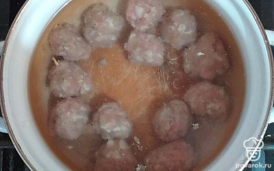 Готовые фрикадельки заложить в кипящую воду. Снять образовавшуюся пену и убавить огонь. Варить 10 минут.