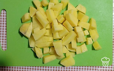 Добавить в бульон порезанную на кубики картошку и варить до готовности.