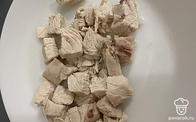 Освободить мясо от костей, нарезать на кубики, добавить в бульон, выключить огонь.