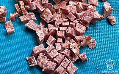 Порежьте на кубики сервелат и добавьте в суп в кастрюлю.