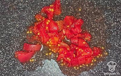 К луку добавляем солёные огурцы. У меня также замороженные, порезанные заранее. Лучше использовать именно солёный огурец. Похожий на бочковой. Маринованные или солёные помидоры очищаем и нарезаем также на кубики. Всё отправляем на сковородку хорошо протушиться. 