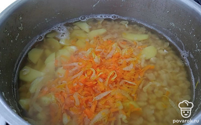 Через 20 минут, когда горох уже немного проварится, добавить к нему картофель, смесь лука и моркови, а также специи и соль. Закрыть крышкой и готовить около 30 минут до готовности. 