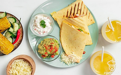 Разрежьте каждую кесадилью на треугольнички. Подайте с соусом гуакамоле и сметаной, посыпав кинзой.