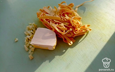 Теперь отправьте в суп мелко рубленный чеснок, сливочное масло и лапшу. Варите 5-7 минут. На этом этапе блюдо стоит попробовать на соль и перец. Дайте супу настояться 10 минут.