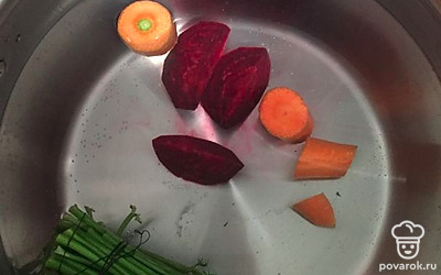 В кастрюлю наливаем воду и кладём туда 1 морковь, одну свеклу, порезанную на 4 части, и зелень. Варим овощной бульон. 