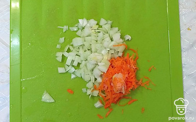 Морковь и лук почистить. Лук порезать кубиками, морковь натереть на терке. Заложить лук и морковь в кастрюлю к мясным шарикам.