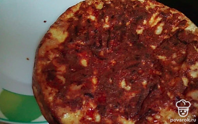 Затем переверните фриттату с помощью тарелки на другую сторону и снова положите на сковороду непрожаренной стороной, готовьте еще 5 минут под крышкой на тихом огне.