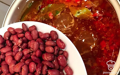 Далее в суп загрузите консервированную фасоль. Перемешайте и дайте закипеть на медленном огне.