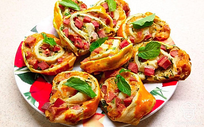 Готовые рулетики слегка остудите, после чего распределите на небольшом блюде. Украсьте закуску веточками свежей зелени, и подавайте к столу.